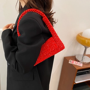 Retro red beaded shoulder bag with hollow design worn by model in black blazer
