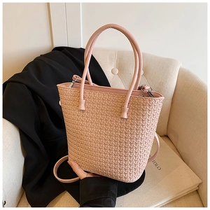 Detailed shot of pink woven tote bag with intricate cross-weave texture and long handles