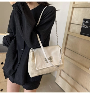 Détail du sac tressé en paille avec rabat en cuir et boucle papillon argentée