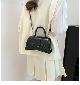 Detail view of the sleek hourglass curve and glossy wrinkled leather texture on the bag