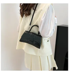 Detail of a black crocodile-embossed hourglass handbag with silver metal hardware