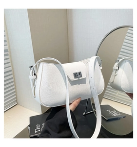 Detailed close-up of white lychee grain leather shoulder bag with silver metal swivel lock