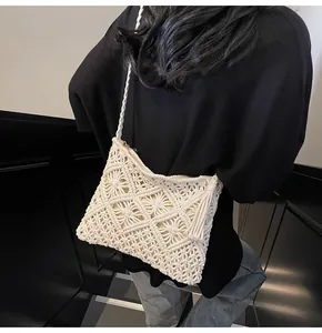 Detailed view of white macrame bucket bag with fringe tassels and woven strap on model