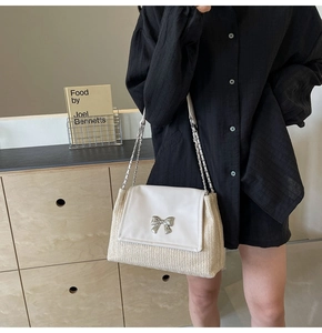 Détail du sac bandoulière en paille tressée avec rabat en cuir et nœud argenté