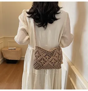 Detail of hand-woven beige bucket bag with tassel and textured knit patterns