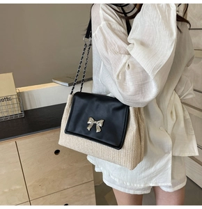 Détail du sac à bandoulière en paille tressée avec rabat en cuir noir et nœud argent
