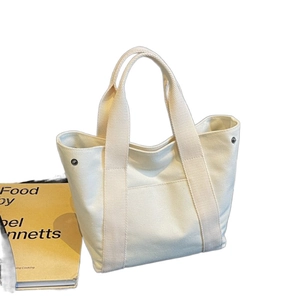 Versatile off-white canvas tote bag for women featuring front pocket and metal side snaps