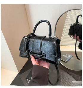 Close-up of black wrinkled patent leather handbag with silver metallic buckle detail