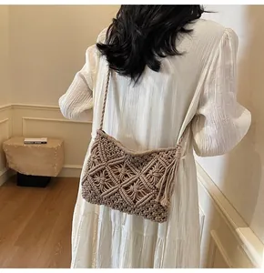 Detail of bohemian macrame bucket bag with fringe tassels and hand-woven diamond pattern
