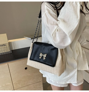 Vue détaillée du sac à bandoulière en paille tissée avec rabat en cuir noir et nœud argenté
