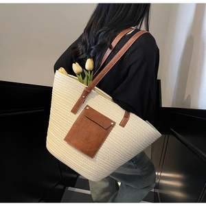 Detail view of woven tote bag with brown leather pocket and tulips inside for daily use