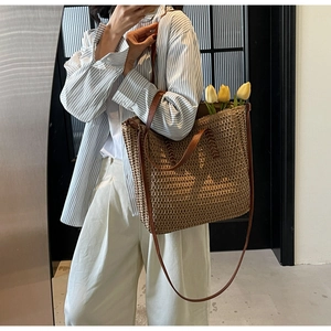 Detail of handwoven straw tote with premium brown leather straps and fine texture