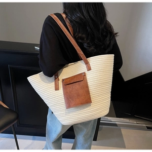 Detail of woven tote bag featuring brown leather shoulder straps and front flap pocket