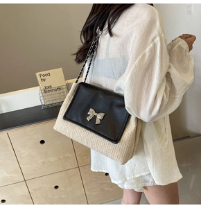 Détail du sac à bandoulière en paille avec rabat en cuir et boucle noeud argenté