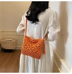 Detail of orange hand-woven bucket bag with hollow geometric patterns and fringe