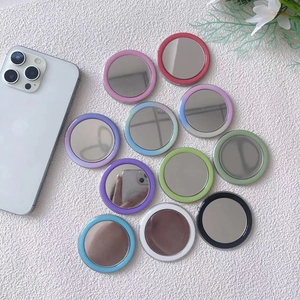 Detailed flat lay of eleven colorful magnetic mini makeup mirrors on a white surface