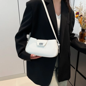 Minimalist white leather crossbody bag with silver lock worn over a black blazer