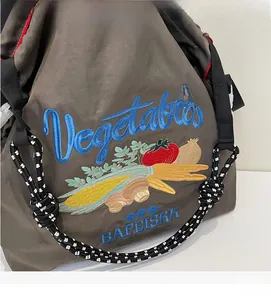 Broderie détaillée de légumes sur un grand sac cabas en nylon brun avec anse tressée