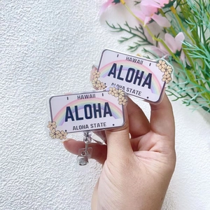 Détail d'un porte-badge rétractable en acrylique arc-en-ciel Hawaii Aloha tenu