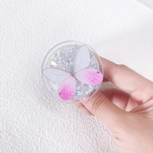 Detail of round magnetic phone socket with silver glitter and pink butterfly pattern