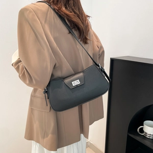 Black pebbled leather underarm bag with silver turn-lock clasp shown on a model