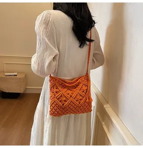 Detail of orange hand-woven bucket bag featuring bohemian hollow patterns and long tassels