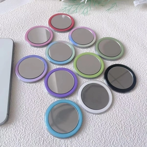 Flat lay of colorful portable magnetic makeup mirrors in various vibrant gradient finishes