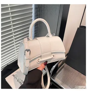 Detail of white hourglass handbag with textured faux leather and silver metal hardware