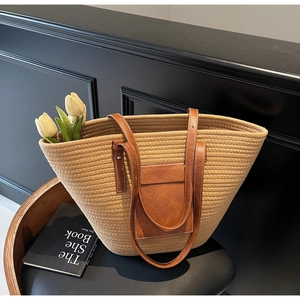 Detail of large khaki woven tote bag with brown leather straps and tulip accents