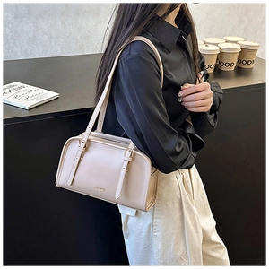 Dettaglio della borsa a spalla urbana beige chiaro con spalline regolabili in un caffè