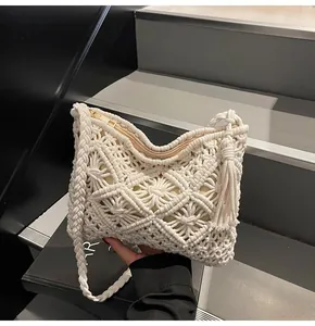 Detail of macramé bucket bag showing geometric hollow knit patterns and fringe tassels