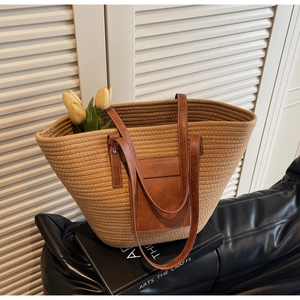 Detail of hand-woven tote bag with brown leather shoulder straps and front pocket