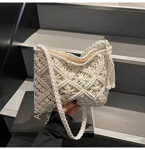 Detail of cream macramé bucket bag showing intricate woven patterns and tassel accent