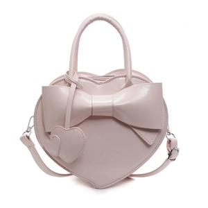 Pink heart-shaped shoulder bag with large bow and dual handles in a minimalist style