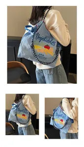 Détail du sac bandoulière bleu clair avec broderie de légumes et bandoulière en corde rayée