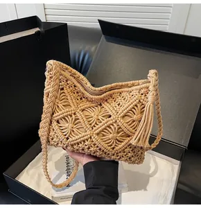 Detailed view of handmade knitted bucket bag with geometric hollow patterns and tassels