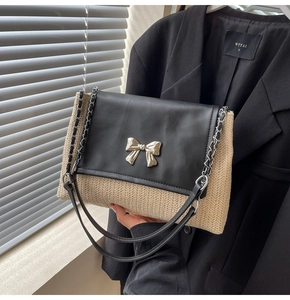 Détail du sac bandoulière en paille tressée avec rabat en cuir noir et nœud argenté
