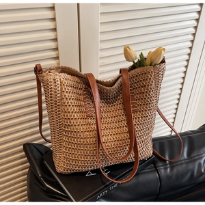 Detail of straw woven tote bag with brown leather straps and interior tulip decor