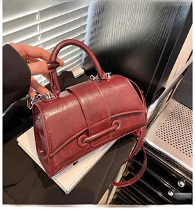 Detail of burgundy hourglass handbag with shiny wrinkled texture and silver hardware