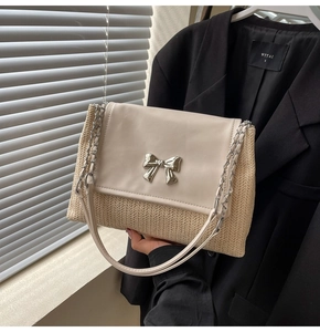 Détail du sac bandoulière en paille tressée avec boucle nœud argenté et chaîne