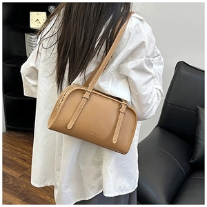 Vista posteriore di una modella con borsa a spalla in pelle marrone e fibbie