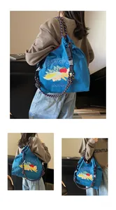 Sac fourre-tout en toile bleue avec broderie légumes porté par un mannequin