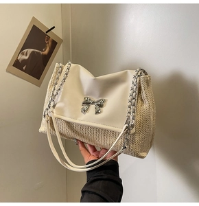 Détail du sac bandoulière en paille tressée avec rabat en cuir et nœud argenté