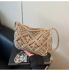 Detail of hand-woven macramé bucket bag with bohemian tassels and premium beige texture