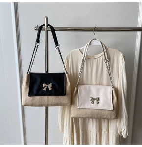 Détail du sac à bandoulière tissé avec rabat en cuir et fermoir en forme de nœud argenté