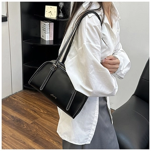 Dettaglio della borsa sottobraccio in pelle nera con cuciture a contrasto e logo Sccery