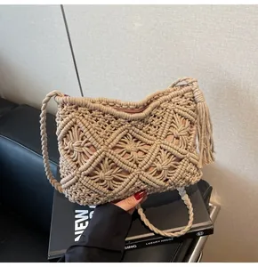 Close-up of beige crochet bucket bag with diamond knit pattern and tassel detail