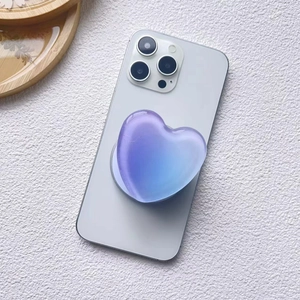 Detail of a blue and purple gradient heart-shaped MagSafe phone socket on a white surface