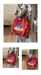 Gros plan d'un sac cabas en toile rouge avec broderie légumes et anse en corde