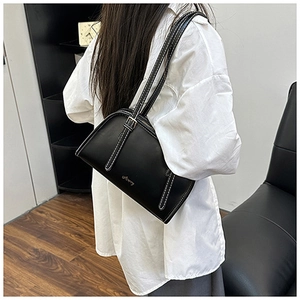 Dettaglio borsa a spalla in pelle nera con cuciture bianche a contrasto e logo dorato